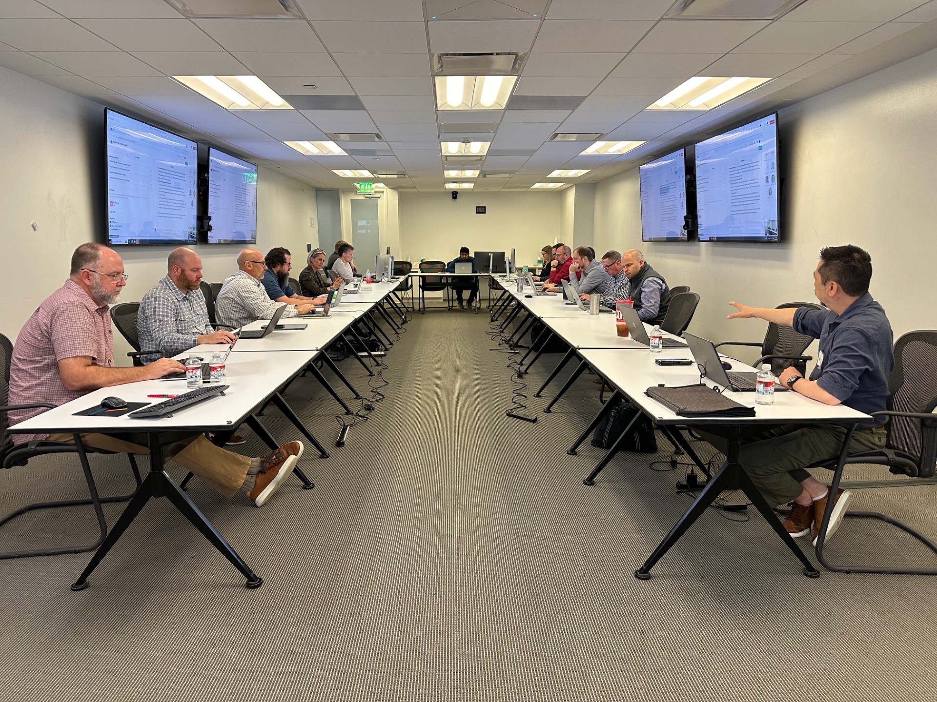 Leaders working on laptops during an AI Working Session